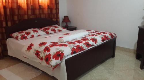 a bedroom with a bed with red flowers on it at Kandy Royal Resort in Kandy