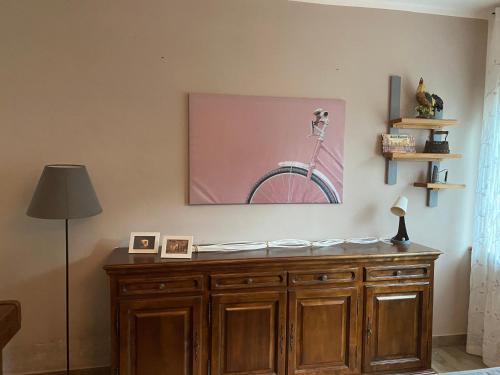 una camera con un armadietto in legno con un dipinto sul muro di Casa Degli Eroi a Gaiole in Chianti
