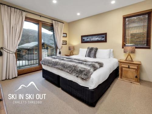 um quarto com uma cama grande e uma janela em On The Snow 1 em Thredbo