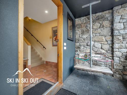 a door to a room with a stone wall at On The Snow 1 in Thredbo