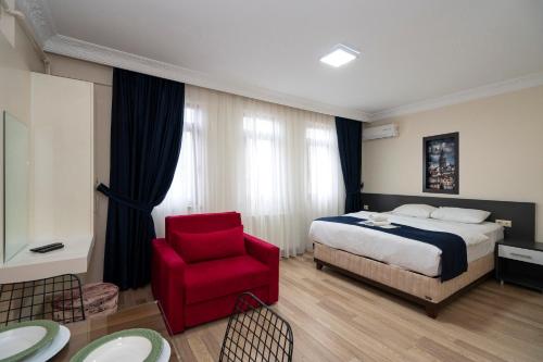 a hotel room with a bed and a red chair at Asteria House in Istanbul