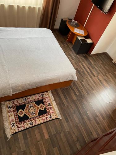 a room with a bed and a rug on the floor at Vila Casa Ta in Sinaia