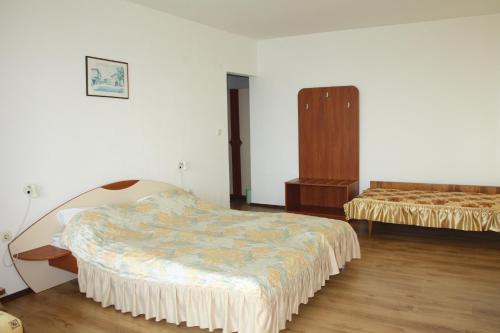 a bedroom with two beds and a dresser in it at Harmony Beach Family Hotel in Nesebar