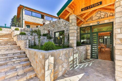 a stone house with a stone wall and a door at Elite Apartments in Kolašin