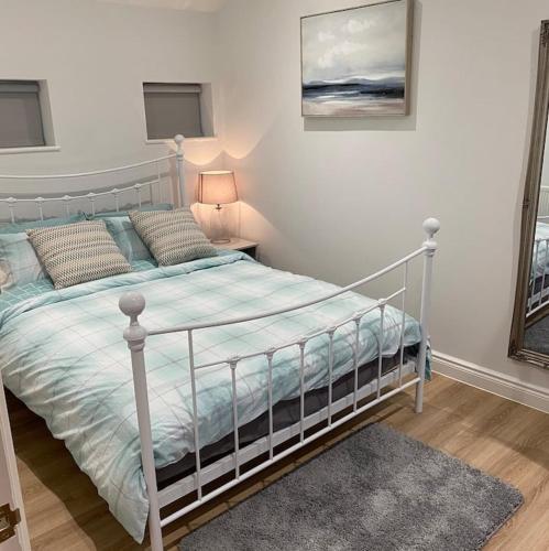 a bedroom with a bed and a lamp in it at Haven Oaks - Self contained rural lodge 2 in Shedfield