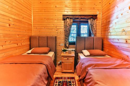 2 łóżka w pokoju z drewnianymi ścianami w obiekcie Elite Apartments w mieście Kolašin