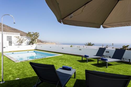 a patio with chairs and a swimming pool at Casa Paraiso with pool and sea view in Candelaria