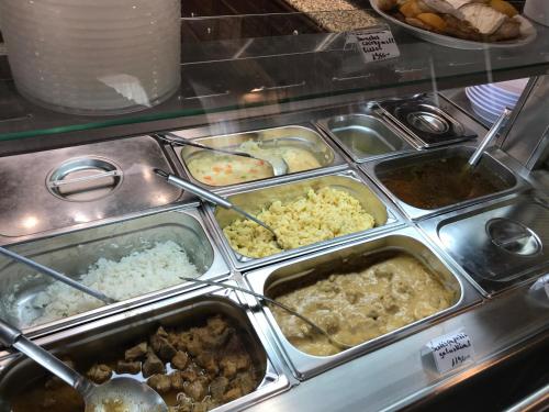 a buffet filled with different types of food in trays at Termál Apartmanház in Veresegyház