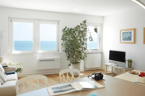 a white living room with a table and a plant at Maison del Bassotto in Numana