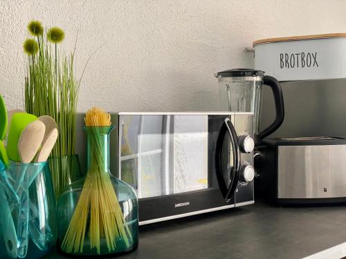 a microwave sitting on top of a counter with vases at Ferienwohnung an der romantischen Salzachschleife Nähe Salzburg in Laufen
