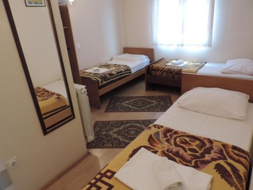 um pequeno quarto com 2 camas e um espelho em Bed and Breakfast Victoria em Ogulin