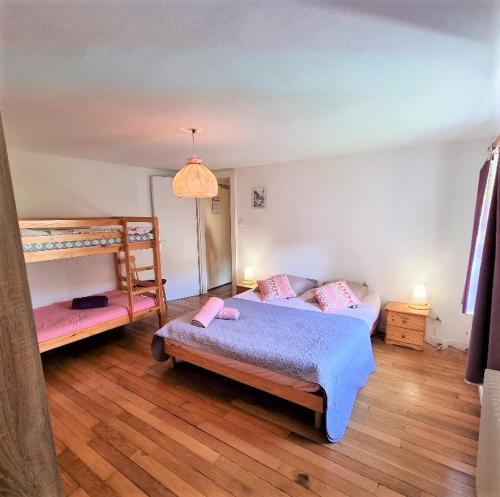 a bedroom with two beds and a bunk bed at Gite Myrtille 2 à 6 personnes dans Residence des Buis avec Spa in Ventron