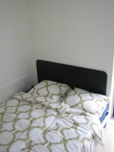 a bed with a black headboard and a white comforter at Active BnB Den Haag in The Hague