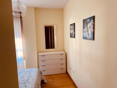 a small bedroom with a dresser and a window at Santiaguiño in Padrón