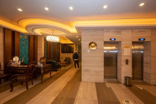 a man walking through a lobby with a piano at Ramada By Wyndham Istanbul Pera Taksim in Istanbul