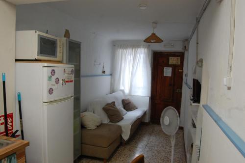 una pequeña sala de estar con sofá y microondas en CASICA TIA CARMEN, en Chulilla