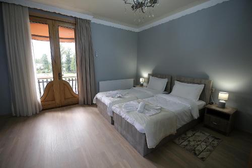 een slaapkamer met een bed en een groot raam bij Hotel Shogi in Zugdidi