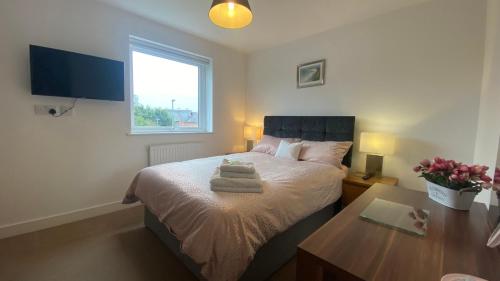 a bedroom with a bed with a table and a window at Comfy 2 bed house located at Wareham train station in Wareham