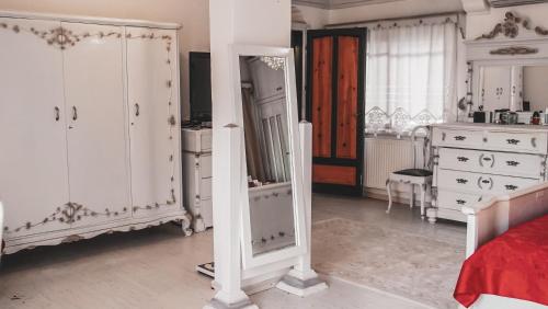 a bedroom with white furniture and a mirror at Muhafazakar Aileye Tam Korunaklı Özel Havuzlu Malikane 8+2 in Bodrum City