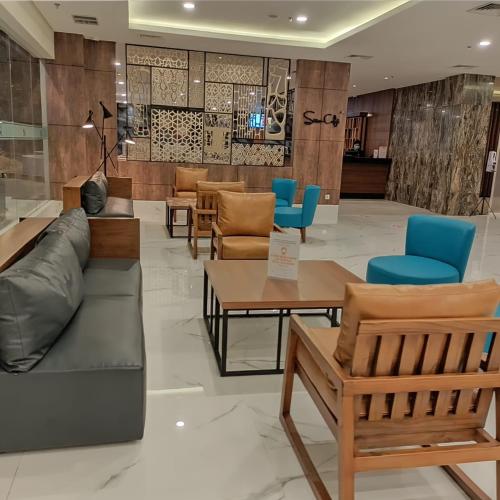 a lobby with a couch and chairs and tables at Swiss-Belhotel Cendrawasih, Biak in Fandoi
