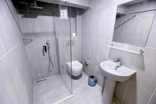 a bathroom with a shower and a toilet and a sink at Kivrak Hotel in Antalya