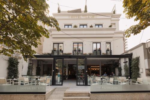 a building with tables and chairs in front of it at Hotel Boutique Vila 135 in Tirana