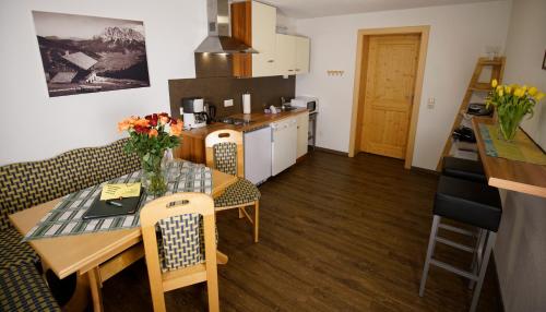 a kitchen and living room with a table and chairs at Alpenstern rooms & suites in Lermoos