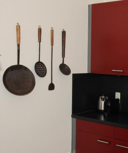 a kitchen with utensils hanging on a wall at Hotel Abdijhof Thorn in Thorn