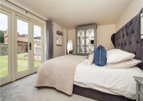 a bedroom with a large bed with a large window at Deer View cottage in Salhouse