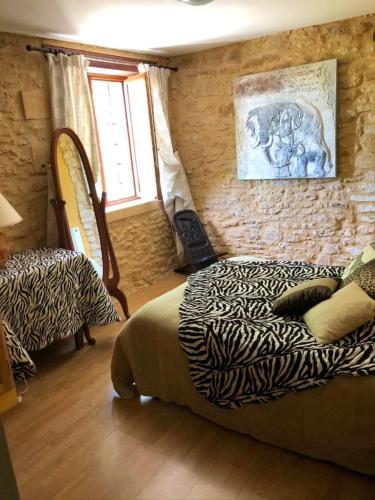 une chambre avec un lit et un mur en pierre dans l'établissement Spacieuse villa à Proissans avec piscine privée, à Proissans