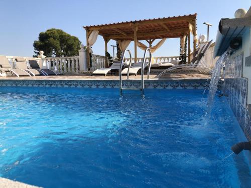 a swimming pool with a water fountain at 4 bedrooms villa with private pool enclosed garden and wifi at Olocau in Olocau