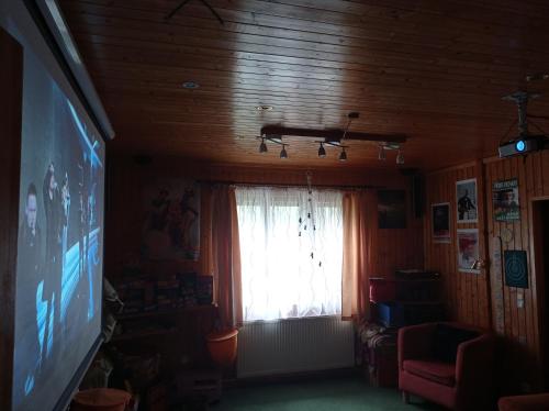 a living room with a television and a window at CHALUPA OSTRAVICE in Ostravice