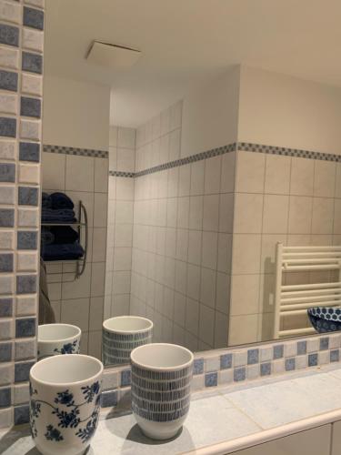 a bathroom with three blue and white cups on a counter at Zeffererhof in Schladming