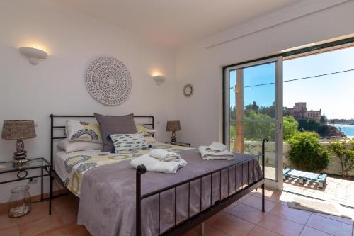 a bedroom with a bed and a large window at Front line townhouse Face la mer in Ferragudo luxury sea views in Ferragudo