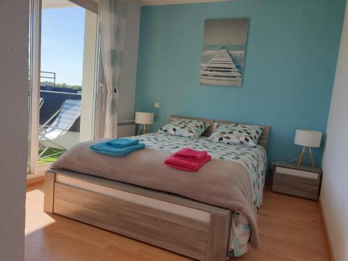 een slaapkamer met een bed met twee handdoeken erop bij Les 2 rivières Appt T3 dans le Golfe du Morbihan in Pluneret