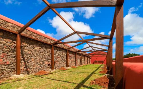 a brick building with a wooden roof and grass at QUINTA DO FALCÃO in Almagreira
