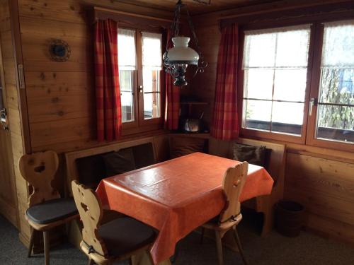 - une salle à manger avec une table et des chaises en bois dans l'établissement Chalet Balfrin Alpweg 9 Postfach 2038 Riederalp, à Riederalp