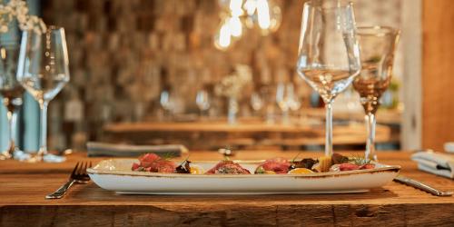 a plate of food on a table with wine glasses at Ferienhauspark Asgard in Damp in Damp