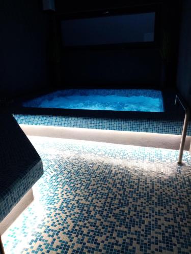 a hot tub in a room with a tiled floor at Vila Gosen in Şard