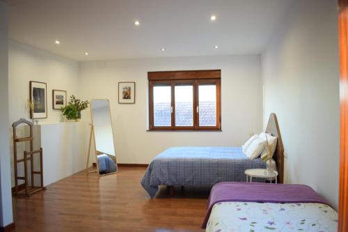 a bedroom with a bed and a window at Playa de Carnota - SondeLira in Lira