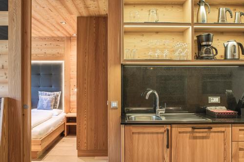 eine Küche mit einem Waschbecken und ein Wohnzimmer in der Unterkunft Chalet Residence Alpinflair in St. Ulrich in Gröden