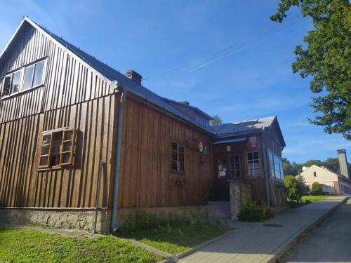 a large wooden building with a fence around it at SzSM Hadle Szklarskie in Hadle Szklarskie