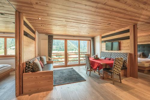a dining room with a red table and chairs at Chalet Residence Alpinflair in Ortisei