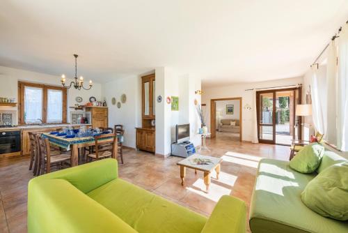 sala de estar con sofá verde y mesa en Villa Clemente, en Lucignano