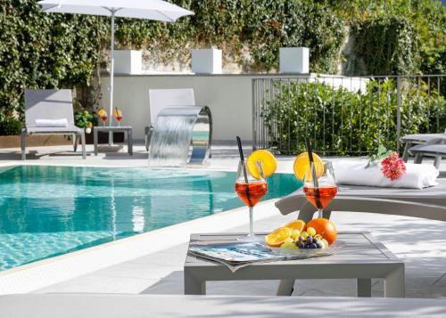 una mesa con bebidas y fruta junto a la piscina en Villa Gremì - Monforte d'Alba, en Monforte dʼAlba