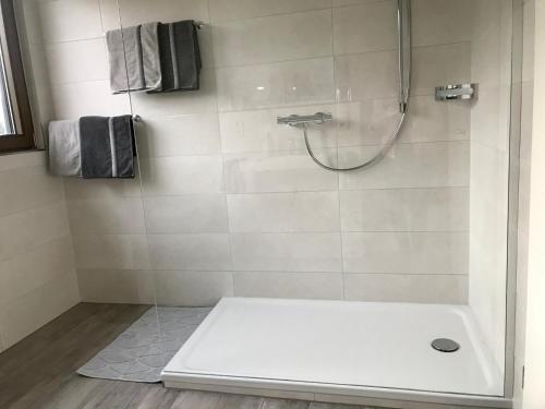 a bathroom with a shower with a white tub at Kalverkamp Ferienwohnung in Lieser