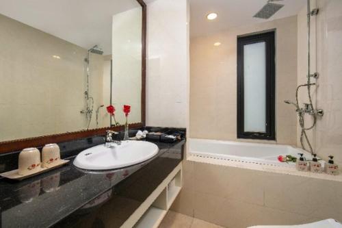 een badkamer met een wastafel en een bad bij PING DIAMOND HOTEL in Hanoi