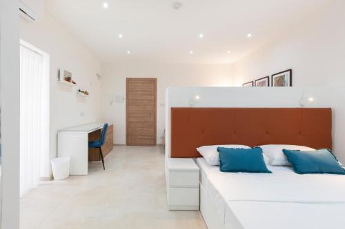 - une chambre avec un grand lit blanc et des oreillers bleus dans l'établissement FL56 - New 3storey House - private entrance & roof, à Il-Furjana