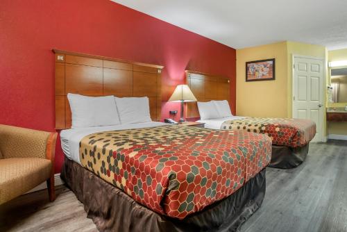 una habitación de hotel con 2 camas y una silla en Econo Lodge, en Tupelo