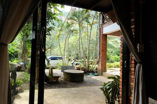 an open door of a house with a car in the background at Ashi Guesthouse Chiangdao in Chiang Dao